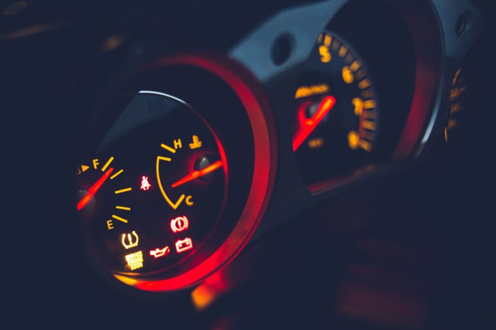Closeup of oil pressure gauge with arrows and scale on instrument panel in modern auto