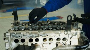 Close-up of a mechanic inspecting an engine for maintenance and repair in a workshop.